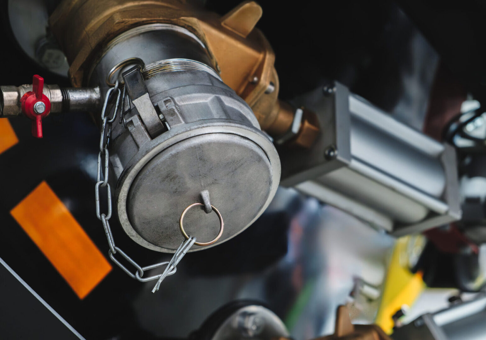 Close-up of bronze valves and pneumatic actuators mounted on industrial machinery. The setup highlights crucial elements for fluid control and automation in a factory environment.